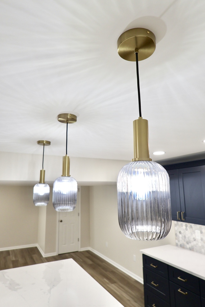 Close-up of pendant light with brass mount in custom basement by Clear Contractors in Crown Point, IN