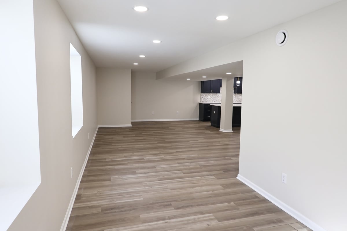 Long basement hallway view with windows and wood-look floors in Clear Contractors custom home in Crown Point, IN