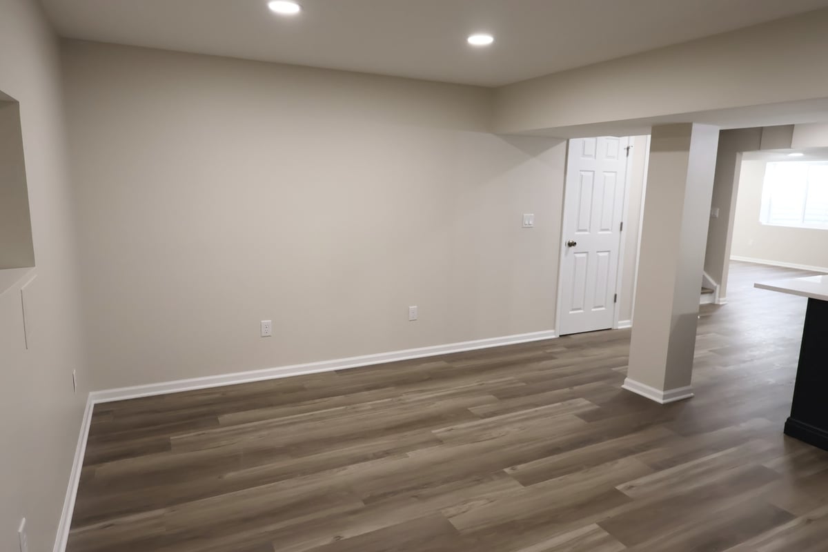 Long view of finished basement with custom kitchen by Clear Contractors in Crown Point, IN