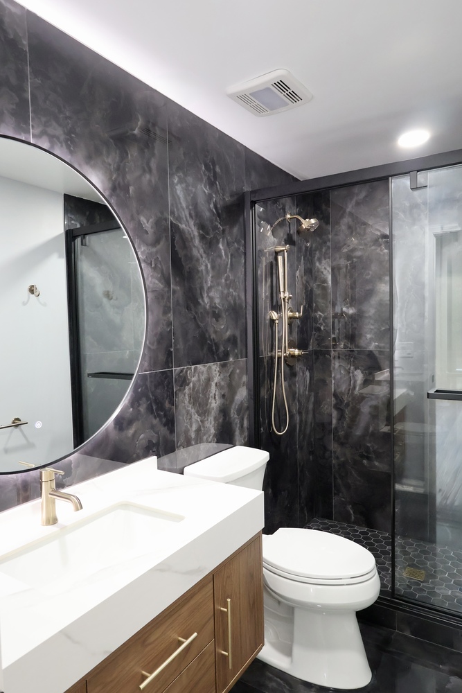 Full bathroom view showcasing black tile walls and glass shower by Clear Contractors in Crown Point, IN.