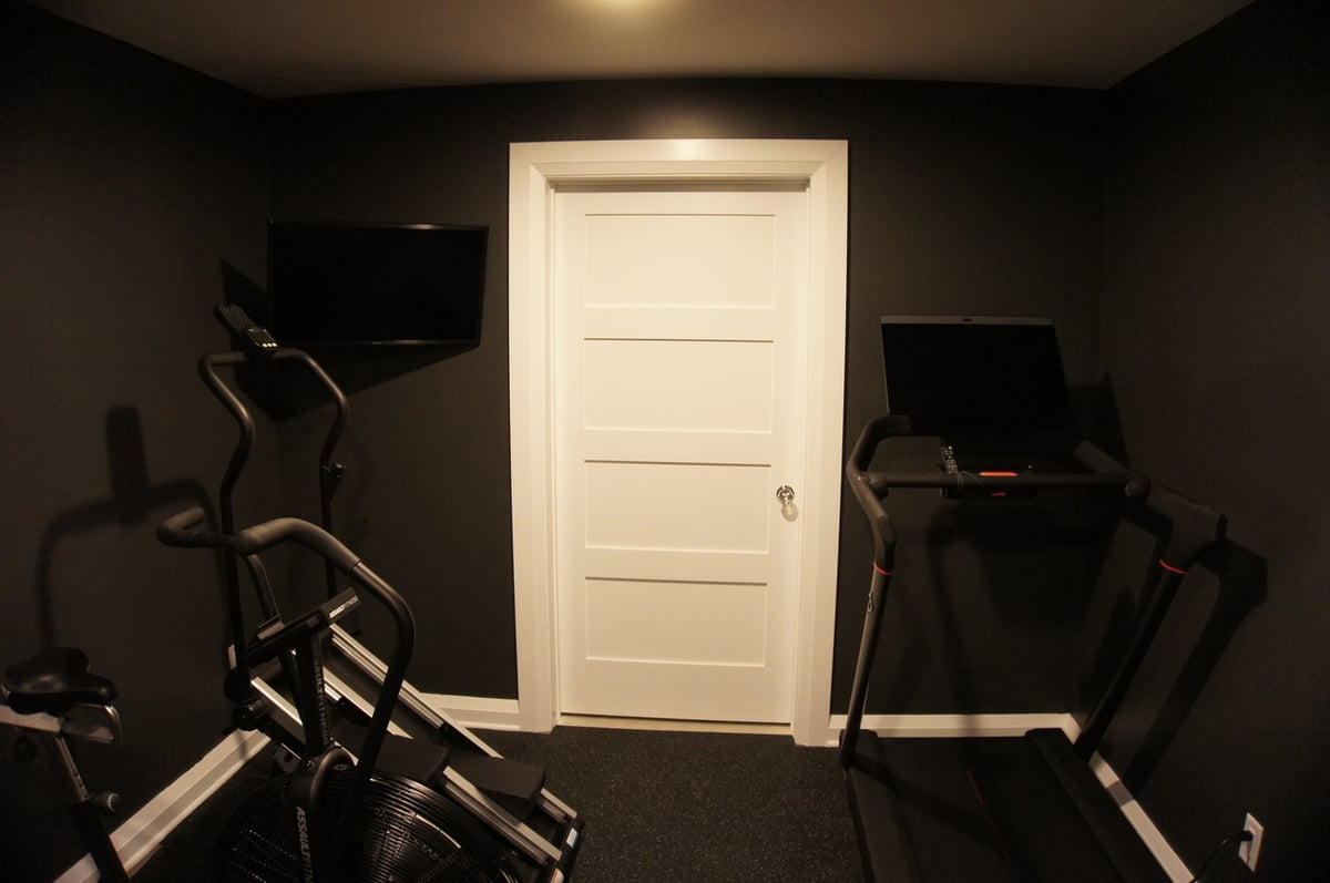 Basement workout area with treadmill and exercise bike for Basement + Bathroom Remodel in St. John