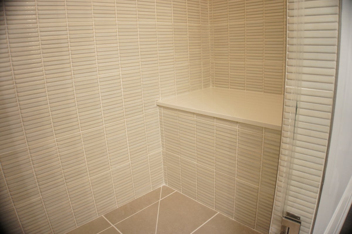 Built-in shower bench with beige tile surround for Basement + Bathroom Remodel in St. John