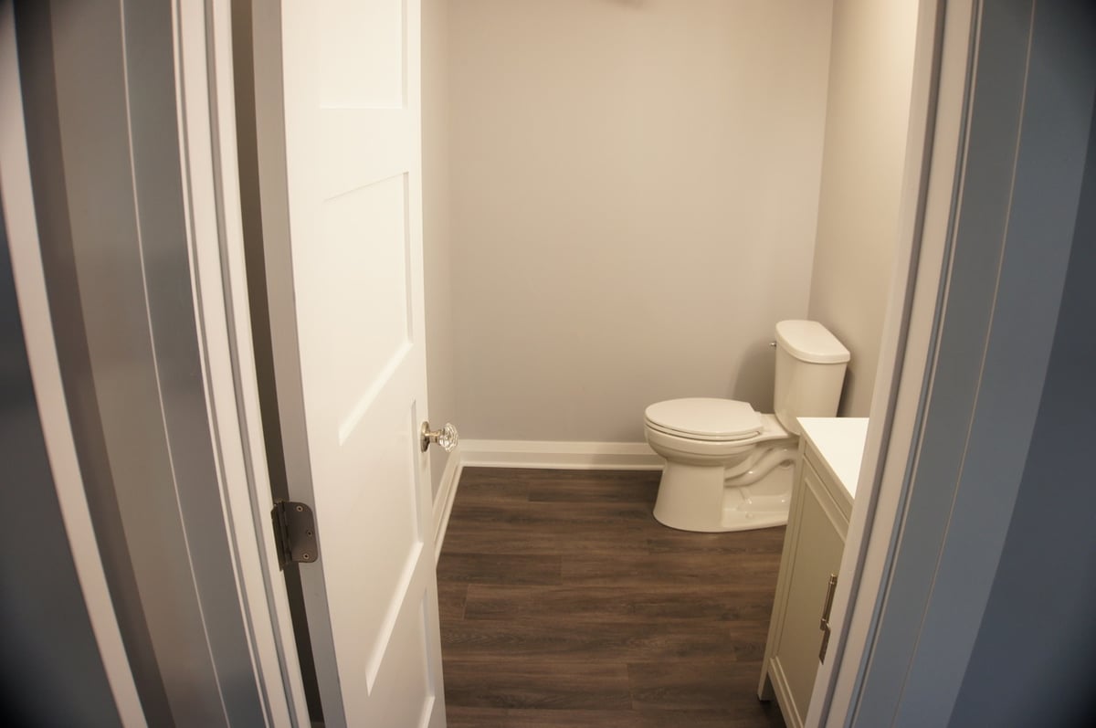 Modern half bathroom with white fixtures for Basement + Bathroom Remodel in St. John