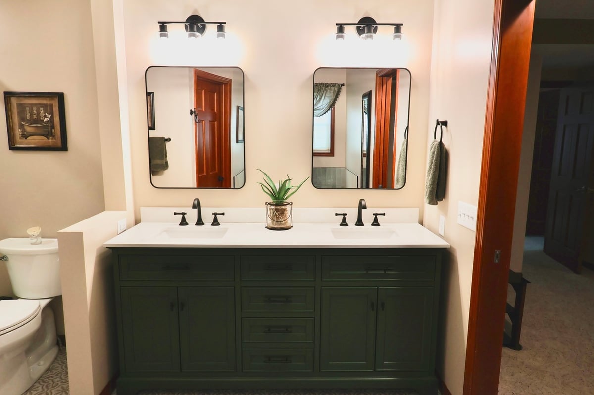 Bathroom remodel in Lowell featuring green vanity and decorative tile flooring