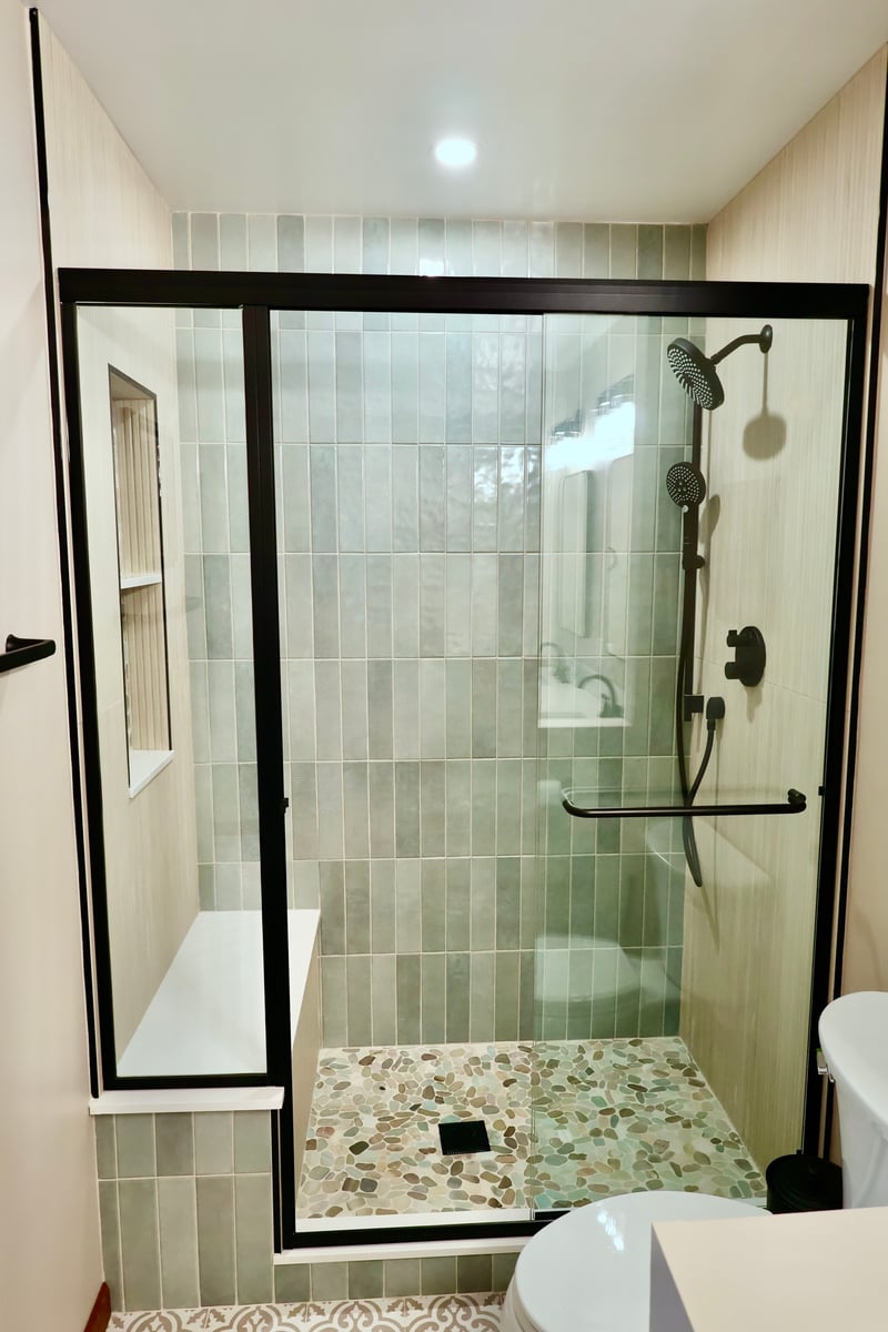 Walk-in shower with glass door and pebble floor in Lowell bathroom remodel