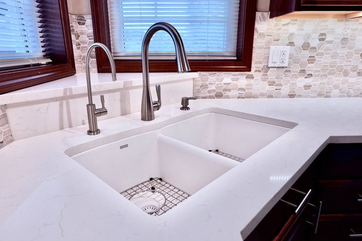 White quartz countertops and brushed metal fixtures from kitchen update in Lowell