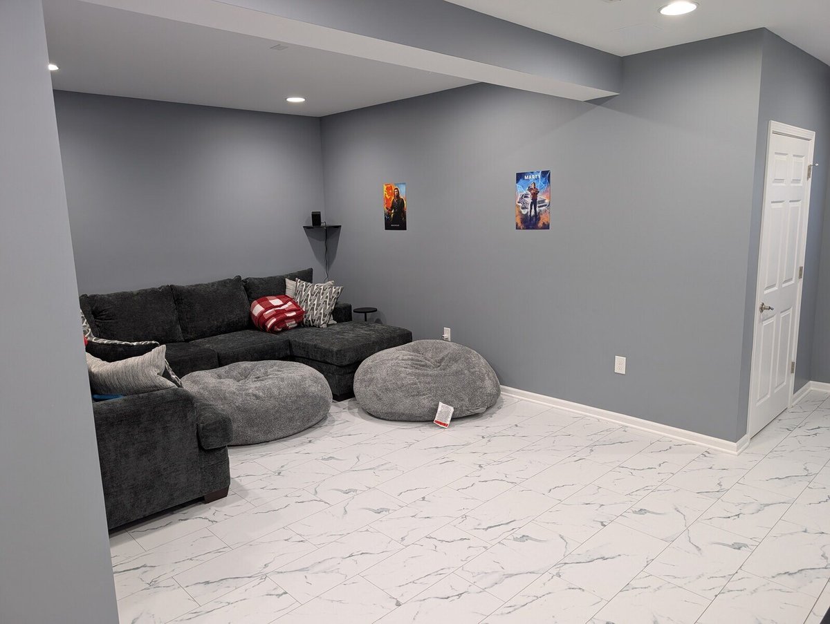 Cozy basement living area with a sectional couch and modern decor by Clear Contractors in Northwest Indiana