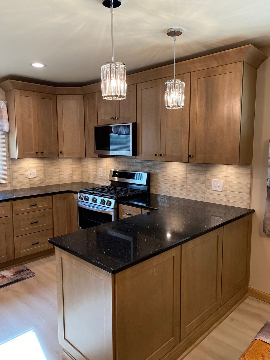 Corner layout with gas range and wood cabinetry in a kitchen remodel in Lynwood by Clear Contractors