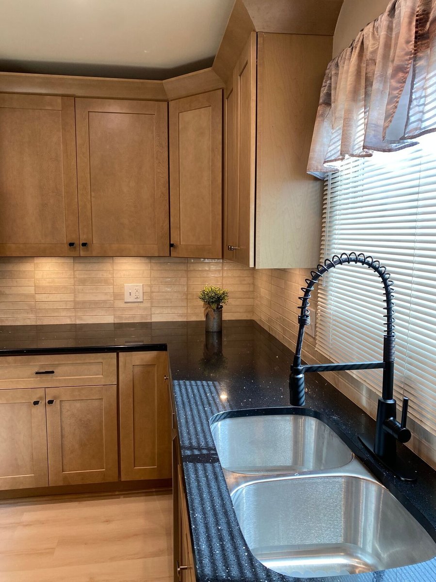 Double stainless steel sink with black pull-down faucet in a kitchen remodel in Lynwood by Clear Contractors