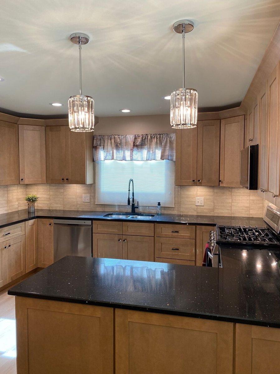 Full kitchen view with black granite countertops and wood cabinets in a kitchen remodel in Lynwood by Clear Contractors