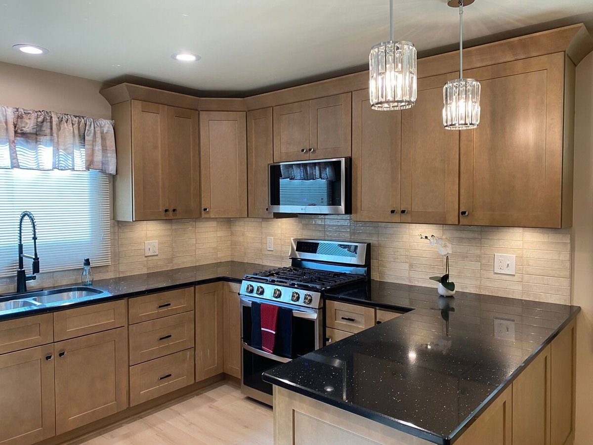 Kitchen featuring built-in microwave and new lighting fixtures from a kitchen remodel in Lynwood by Clear Contractors