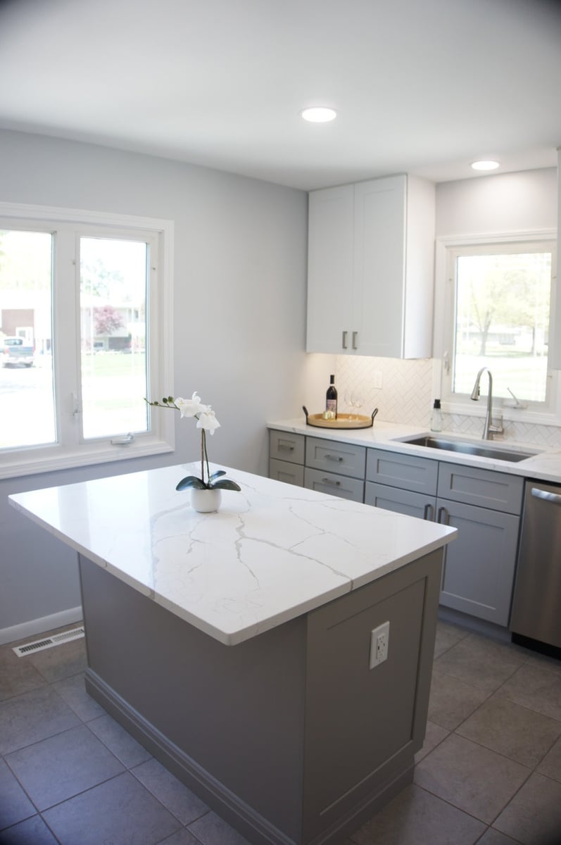 Kitchen island with white quartz countertop and gray base cabinets for Kitchen Remodel in Munster