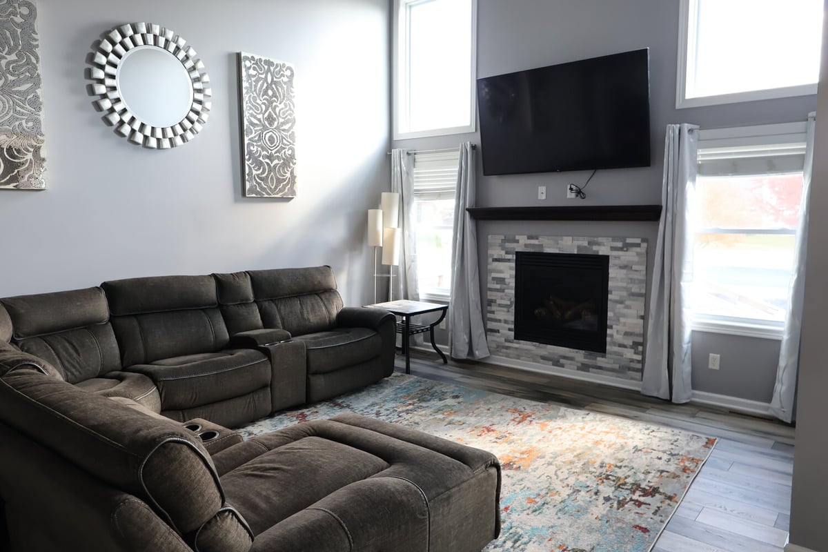 Living room with sectional sofa, fireplace, and accent decor in a Schererville custom home by Clear Contractors.
