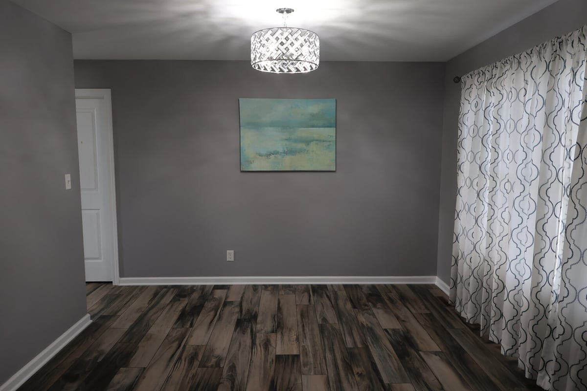 Modern dining area with gray walls and dark wood-look floors in a Clear Contractors custom home in Schererville, IN.