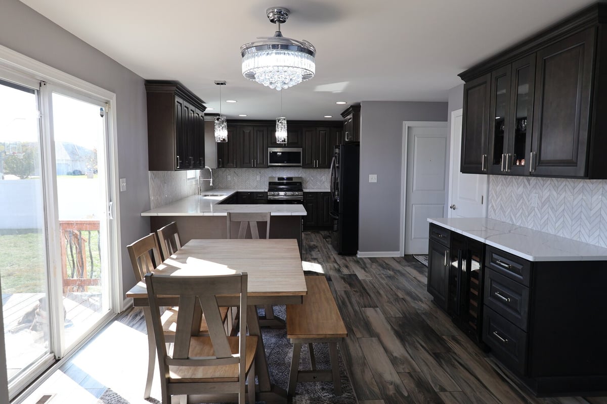Open kitchen and dining area with dark cabinets and quartz countertops in a Clear Contractors custom home in Schererville, IN.