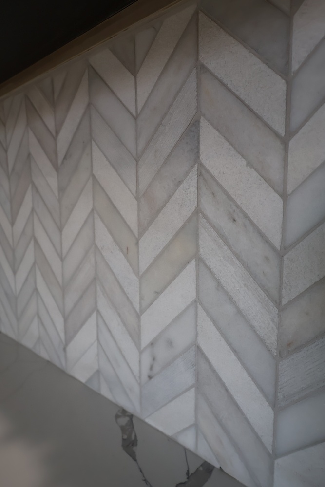 Vertical view of marble herringbone backsplash with veining detail by Clear Contractors in Schererville, IN.